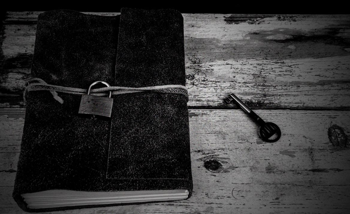 diary with a lock on a table with a key next to it