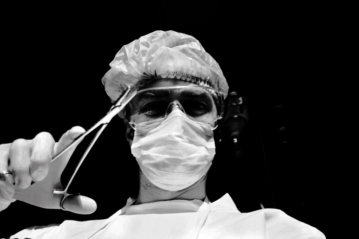 doctor in a mask and ppe with surgical tools