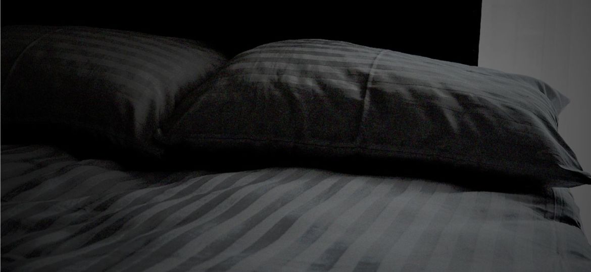 bed with striped sheets and pillow cases