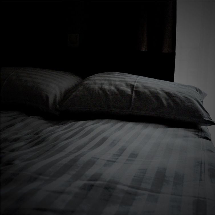 bed with striped sheets and pillow cases
