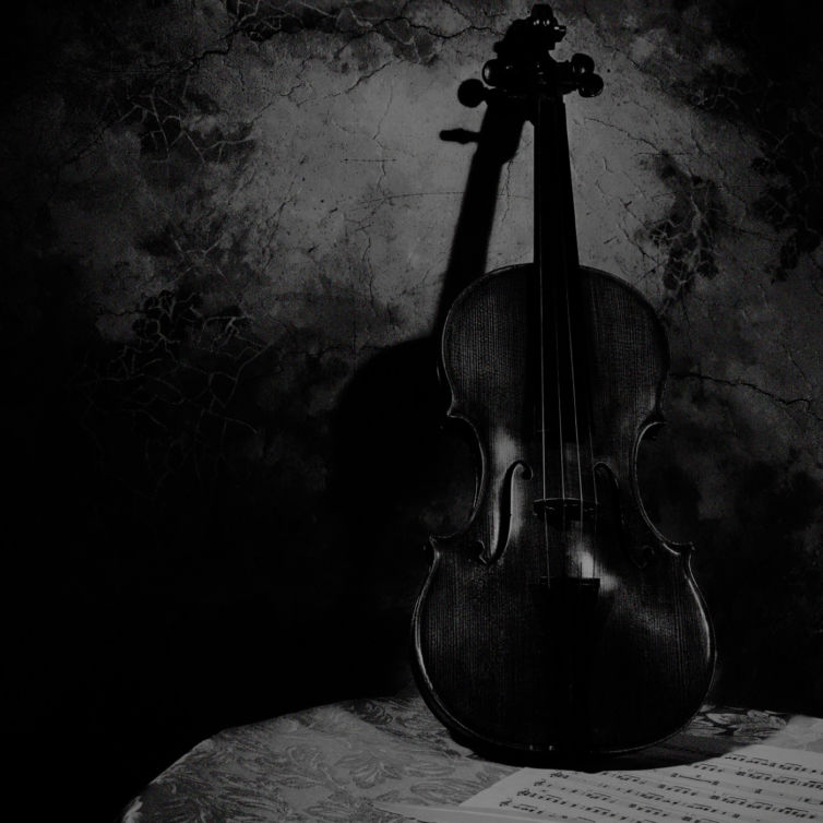 violin on a table leaning against a wall