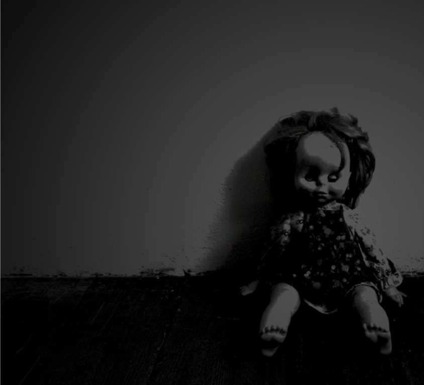 Old doll propped up against a wall